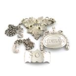 A small collection of five antique silver and electroplated labels, comprising a miniature pair of