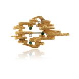 An abstract gem-set gold brooch, c1970, the textured yellow gold mount is set with circular-cut