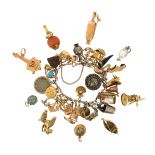 A gold charm bracelet with assorted charms, including a 9ct gold horseshoe, a 9ct gold scallop shell