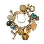 A gold charm bracelet, suspending assorted charms including a spinning compass charm, a garnet and