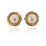 A pair of cultured mabé pearl and diamond ear clips, set within yellow gold borders decorated with