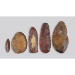 Five stone tools two with a red / pink residue, 7.6cm, 12.1cm, 14.7cm, 17.5cm and 18.5cm long. (5)