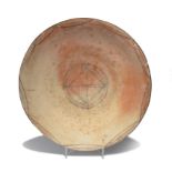 A shallow dish probably Cypriot terracotta, decorated with square, circle and wavy line central