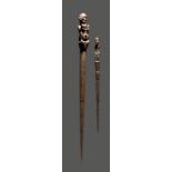 Two Dayak pig sticks tun tun Indonesia with figural finials, 47cm and 71.5cm long. (2)