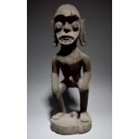 A Dayak guardian figure Borneo, Indonesia standing with hands on the knees, 66.5cm high.