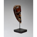 A Bassa passport mask Liberia with a ribbed coiffure, 12cm high, on a stand. (2)