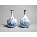 Two delftware vases or guglets c.1750-60, of bottle form with long necks tapering to a flared rim,