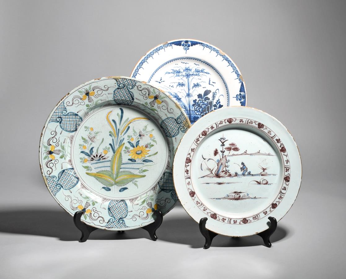 Two delftware chargers mid 18th century, one painted in manganese with blue detailing, with a figure