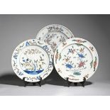 Three large tin-glazed chargers 18th century, one probably London delftware and painted in blue,