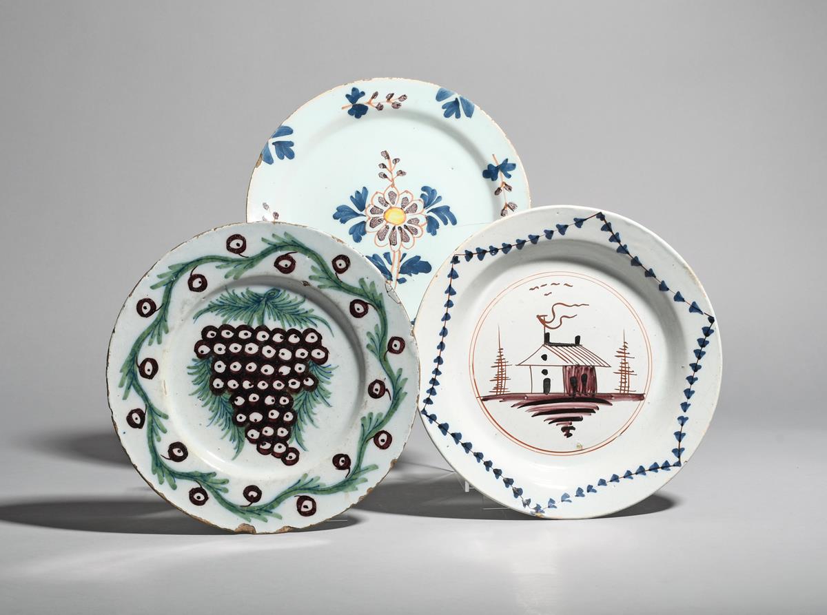 Three delftware plates c.1740-70, probably London, one painted in green and manganese with a large