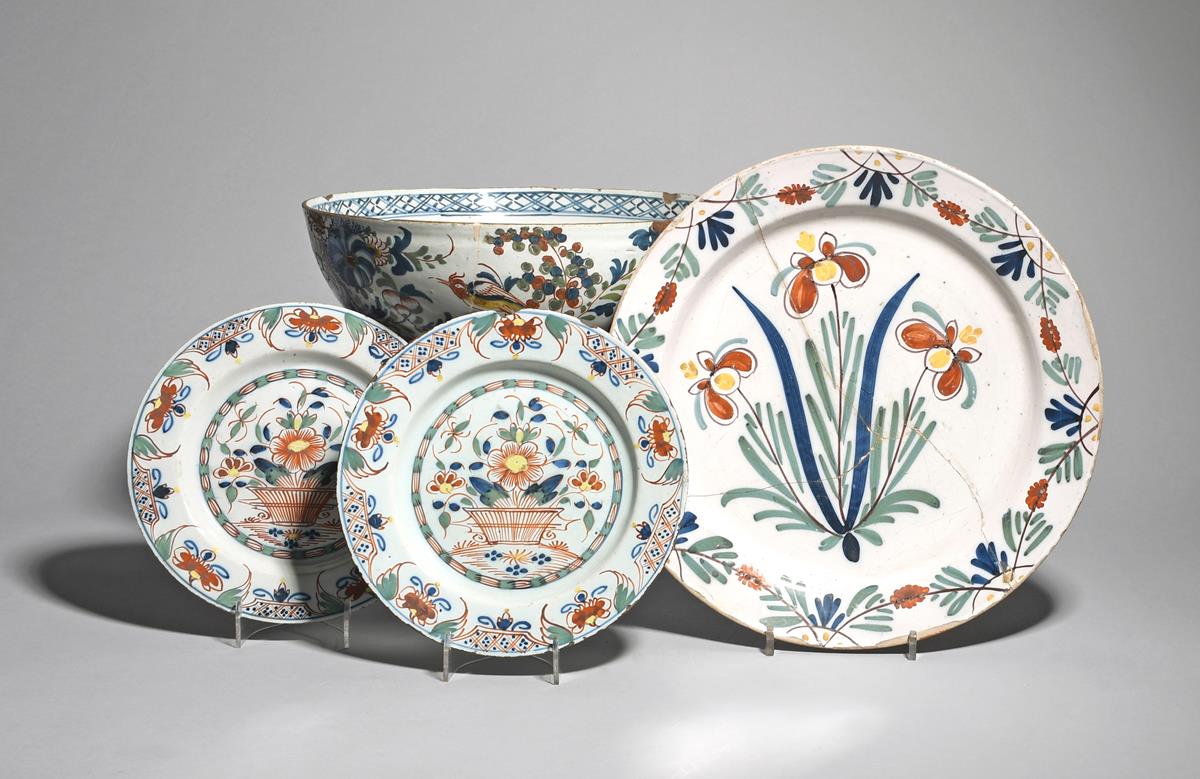 A near pair of Lambeth delftware plates mid 18th century, painted in bold polychrome enamels, each