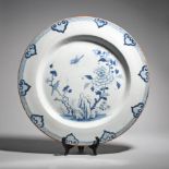 A massive delftware charger c.1760, well painted in blue with a bird in flight above another perched