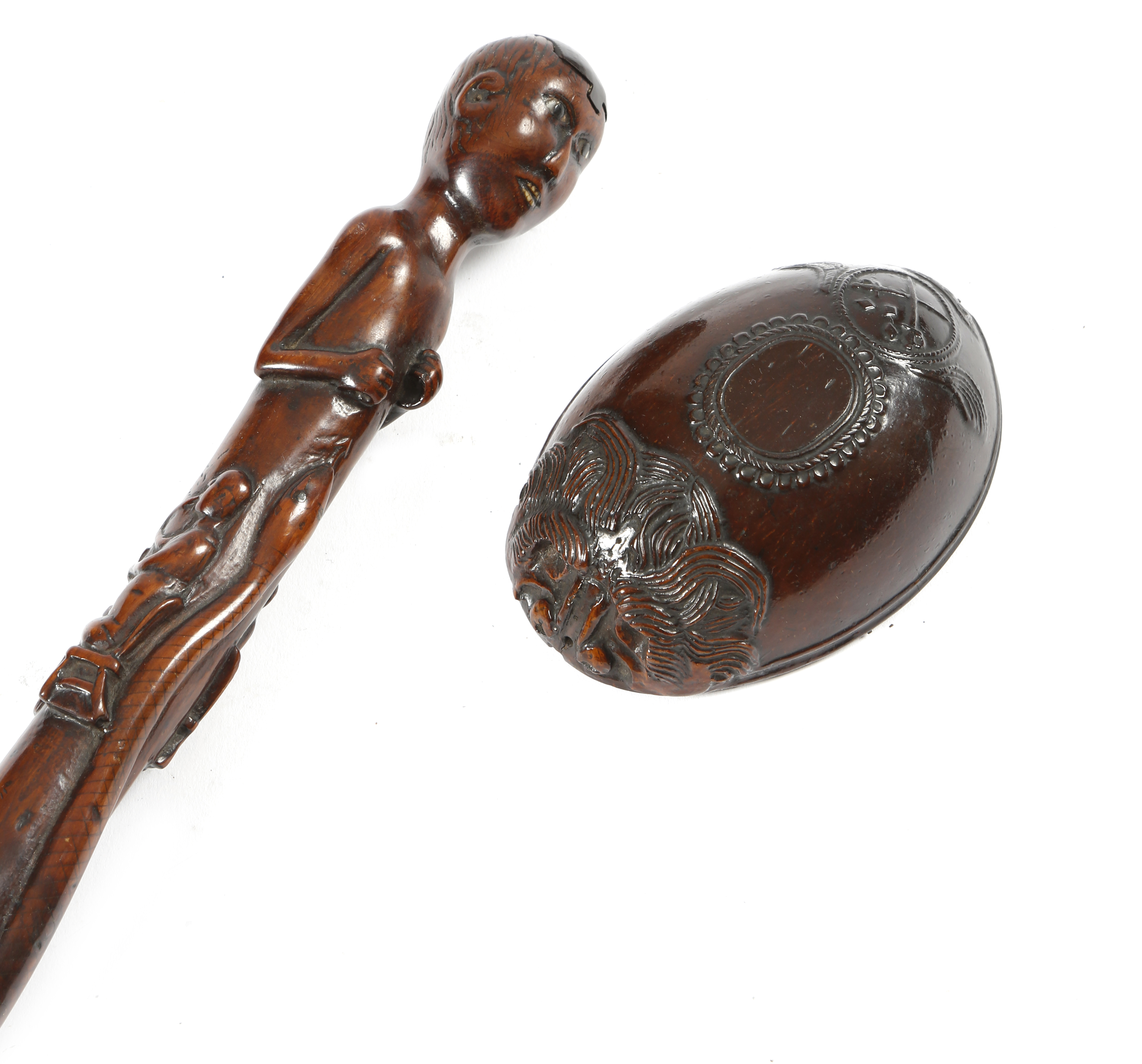 A folk art carved wood naive walking cane, the handle in the form of a native with a sliding cover
