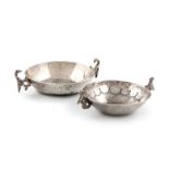 A South American silver wine taster, unmarked, circular form, with stylised bird scroll handles, the