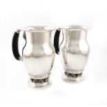 Designed by Georg Jensen, a pair of Danish silver Grape pattern water pitchers / ewers, design no.