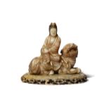 A CHINESE FURONG SOAPSTONE FIGURE OF GUANYIN AND A LION DOG PROBABLY LATE QING DYNASTY The goddess