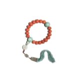 A CHINESE CORAL AND JADEITE ROSARY BRACELET QING DYNASTY The graduated coral beads divided by two
