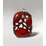 A CHINESE AMBER PENDANT LATE QING DYNASTY Carved in openwork as three large fruits issuing from