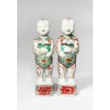 A PAIR OF CHINESE WUCAI FIGURES OF BOYS SHUNZHI 1644-61 Each stands on a square pedestal painted