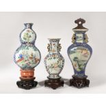 THREE CHINESE FAMILLE ROSE AND GILT-DECORATED WALL VASES 19TH CENTURY One gourd-shaped and painted