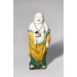A CHINESE SANCAI FIGURE OF BUDAI HE SHANG LATE QING DYNASTY Depicted standing wearing loose robes,
