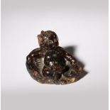 A RARE CHINESE AMBER CARVING OF AN INFANT IN A BASKET MING DYNASTY OR EARLIER The baby depicted