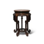 A CHINESE RETICULATED HARDWOOD STAND QING DYNASTY The circular panelled top set above a pierced