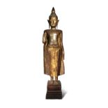 A CAMBODIAN LACQUERED AND PARCEL-GILT WOOD FIGURE OF BUDDHA 19TH/20TH CENTURY Depicted standing in