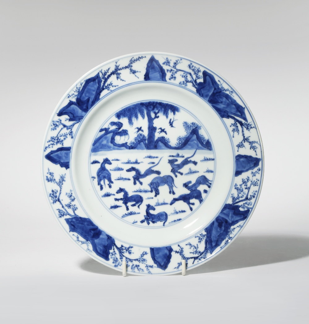 A CHINESE BLUE AND WHITE 'EIGHT HORSES' PLATE KANGXI 1662-1722 Painted with a central scene of the