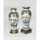 A NEAR PAIR OF CHINESE FAMILLE ROSE VASES 18TH CENTURY The tall baluster-shaped bodies decorated