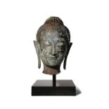 A THAI BRONZE HEAD OF BUDDHA 17TH CENTURY Cast with a serene expression, the face framed by his