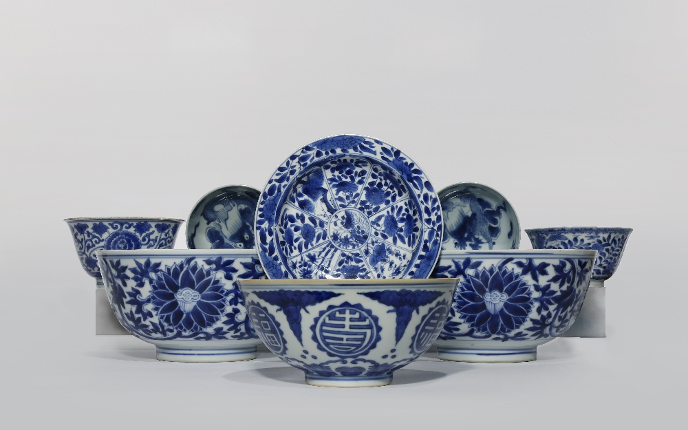 SEVEN CHINESE BLUE AND WHITE BOWLS AND A DISH 18th & 19th C. Variously decorated with flowers,