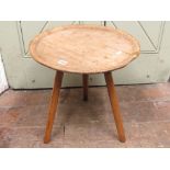 An antique sycamore wood dairy or cheese dish, with raised borders set on a later tripod base,