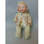 A bisque head baby doll by Armand Marseille with soft trunk and legs and opening and closing eyes,
