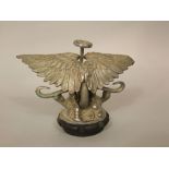 An Edwardian Austin wings and wheels car mascot with silver plated finish mounted on an original