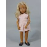 A Sasha doll, with blonde hair and in a pink dress