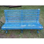 A vintage three seat garden bench with blue painted timber lathes, raised on sprung steel