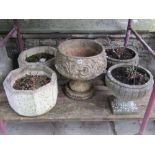 Five contemporary weathered cast composition stone garden urns of varying design, including two