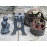 Three small vintage implement wheels of varying size, together with a heavy duty cast iron low