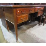 An Edwardian mahogany kneehole writing table fitted with four drawers on square tapered legs, with