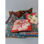 Six cushions with hand stitched needlepoint covers in various patterns, together with two others