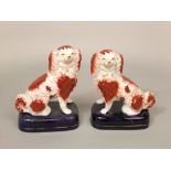 A pair of 19th century Staffordshire spaniels with red and white painted patches and separate