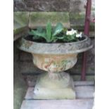 Two weathered cast composition stone garden urns of varying design (planted) a further weathered