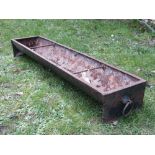 A vintage cast iron pig feeding trough of rectangular form, with rung divisions and ring handles,