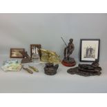 A collection of novelty angling related items to include cold cast resin sculptures of fishermen,