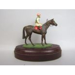 Cold painted cast bronze study of a jockey on horse back, upon an oval wooden plinth base, 12cm