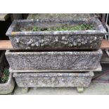 Four weathered cast composition stone flower troughs of rectangular form, all with raised relief