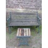 A contemporary two seat garden bench with weathered timber lathes, raised on a pair of cast iron end