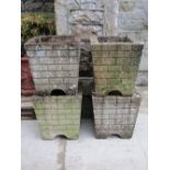A set of four weathered cast composition stone garden planters of square tapered form with faux