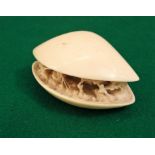 A 19th century ivory carving of a mussel shell, partly open, the interior revealing trees, fishermen